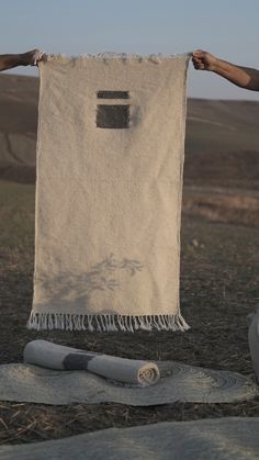 a towel hanging on a clothes line in the middle of a field with rolled up towels