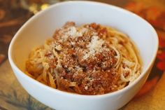 a white bowl filled with pasta covered in sauce