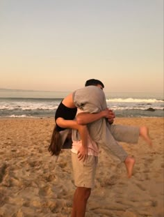 a man and woman hug on the beach