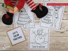 three christmas coloring pages on top of a wooden table