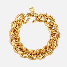 The Christina Caruso Braided Chain Bracelet, is a statement piece that exudes both elegance and substance. Crafted with meticulous attention to detail, this chunky bracelet is dipped in luxurious 14k gold, offering a lustrous finish that catches the eye. Despite its substantial weight, it maintains a comfortable wearability, striking the perfect balance between presence and comfort. Secured with a sophisticated T-bar closure embellished with the brand's iconic logo charm, it's the ultimate acces Formal Yellow Gold Chunky Chain Bracelet, Chic Gold Bracelets With Oyster Detail, Formal Yellow Gold Bracelet With Chunky Chain, Formal Yellow Gold Chunky Chain Bracelets, Classic Oyster Chain Link Bracelet, Gold Metal Chain Bracelet With Oyster Design, Chunky Chain Yellow Gold Bracelet, Yellow Gold Link Bracelets With Chunky Chain, Classic Gold-tone Bracelet With Chunky Chain