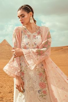 The new party and festive wear collection is all set to grab your attention with Pakistani designer eid dresses. You can buy lavish fancy wear online to adorn your special event look in an elegant way. Shirt: This lavish festive attire is showing its grace with elegant white color embroidered panels for shirt. Lawn shirt is embellished with embroidered front and printed back panel. Neck is designed with lawn embroidered neckline. Lawn sleeves are designed with beautiful prints. Shirt has beautif Pink Floral Outfit, Eid Outfits Pakistani, Eid Dresses Pakistani, Eid Dress Design, Maria B Lawn, Salwar Kameez Online Shopping, Dresses Pakistani, Lawn Dresses, Dress Pakistani