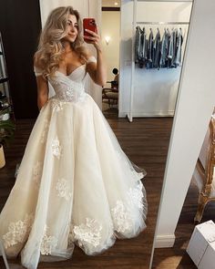 a woman is taking a selfie in her wedding dress while looking into the mirror