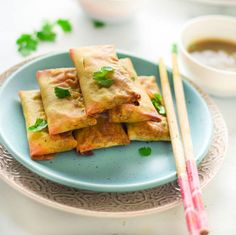 some food is on a blue plate with chopsticks