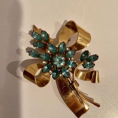 "This brooch is vintage Coro Craft signed sterling with gold vermeil overlay. It is a gorgeous showy, statement bow shape with aquamarine rhinestones in a flower and leaf motif. It was made in the 1948 and the condition is consistent with the age of this brooch, having some signs of wear but as beautiful as ever. The brooch measures approx. 3 1/4\" x 2 1/4\".  Wear this on a sweater or coat or perhaps pin it to a black purse. Great gift idea for a vintage jewelry collector or just for you." Mid-century Yellow Gold Brooch For Gifts, Mid-century Yellow Gold Brooch Jewelry, Gold Art Deco Brooches For Anniversary, Mid-century Yellow Gold Brooch, Gold Art Deco Anniversary Brooches, Gold Art Deco Brooch For Evening, Gold Art Deco Brooches For Evening, Art Deco Gold Brooches As Gift, Gold Art Deco Brooches As A Gift