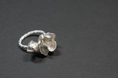 -Product description- Handmade sterling silver (925) jasmine ring. The ring shank is handmade with twisted and beaded wire. The inner surface of the jasmine petal was carefully hand textured to be shimmery. While the outer layer was smooth and shiny, to give a beautiful contrast. A freshwater pearl was then attached to give an elegant touch. Great as a gift for her, or a treat for yourself. The jasmine blossom and bud part are about 25mm in length (1 inch) and 17mm (11/16 inch) in width, weighin Adjustable Delicate Silver Pearl Ring, Delicate Silver Pearl Ring Gift, Elegant Adjustable Sterling Silver Flower Ring, Handmade Delicate Silver Flower Ring, Delicate Handmade Silver Flower Ring, Silver Delicate Flower Shaped Ring, Delicate Silver Flower-shaped Ring, Delicate Silver Ring With Flower Shape, Elegant Handmade White Gold Flower Ring