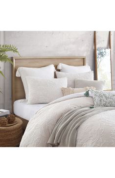 a bed with white comforters and pillows