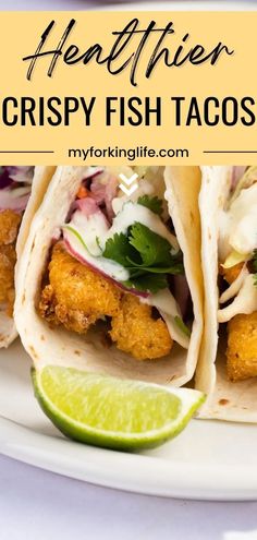 three fish tacos on a plate with lime wedges