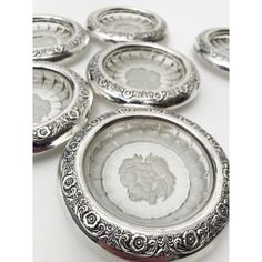 six silver plates with designs on them