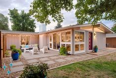 a backyard with a patio, dining room and living area in the middle of it