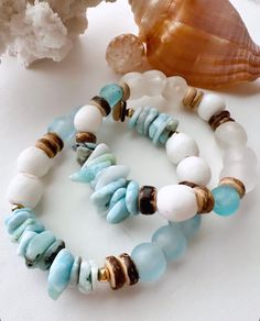 Great bracelet for all seasons! Add something fresh and new to your accessory collection that can be stacked, worn alone or mixed together with your favorite pieces. These uniquely ornate beachy inspired neutral IzaTazi bracelets will definitely make your look stand out! this bracelet features:  1 Size 7" stretch style bracelet    Organic shaped Larimar chips  Blue and white African recycled sea glass beads  14K Gold filled accents  Coconut shell beads  BRACELET CARE INSTRUCTIONS: *Keep jewelry Ocean-inspired Beaded Bracelets For Beach, Bohemian Strand Bracelets For Beach Season, Beachy Shell Beaded Bracelets For Beach Season, Bohemian Beaded Bracelets With Natural Stones For Beach, Blue Stackable Friendship Bracelets For Beach, Beachy Bracelets For Beach Season, Bohemian Stackable Stretch Bracelet For Beach, Blue Stackable Jewelry For The Beach, Bohemian Strand Bracelets For Beach Party