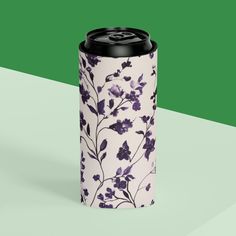 a can cooler with purple flowers on it and a green stripe in the back ground