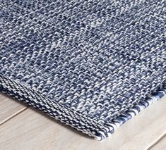 a blue and white rug on top of a wooden floor next to a wood floor