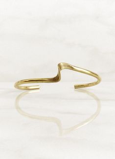 Ola meaning wave in Spanish, illustrates how this simple bangle mimics the soft, undulating rhythm of disturbed water. It offers an understated sophistication. Sister style to the Ola Earrings. Solid brass. This piece is made to order, please allow 7-14 days for delivery. Elegant Adjustable Wavy Bracelets, Elegant Adjustable Wavy Bangle, Modern Wavy Jewelry For Formal Occasions, Simple Bangle, Brass Bangle, In Spanish, Solid Brass, Bangle Bracelets, Gold Bracelet