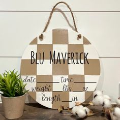 a wooden sign that says blu maverick on it next to some cotton plants