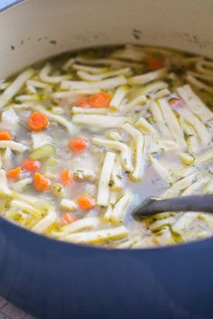 a pot filled with chicken noodle soup on top of a table