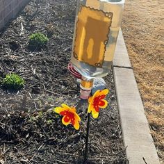 a yellow and red flower sitting on top of a wooden pole next to a brick wall