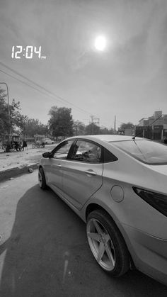 a car is parked on the side of the road in front of an alarm clock