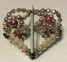 a heart shaped brooch sitting on top of a table