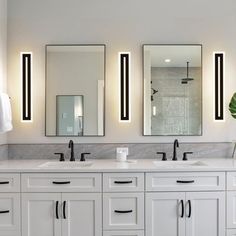 a bathroom with two sinks and three mirrors