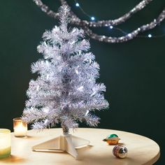 a small white christmas tree sitting on top of a table