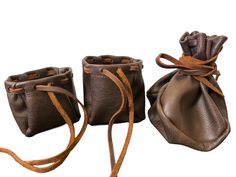 three brown leather pouches tied together on a white background