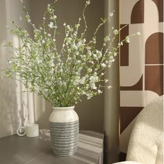 a vase filled with white flowers sitting on top of a table