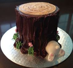 there is a cake that looks like a tree stump with an animal on the top