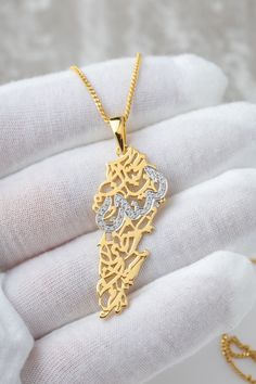 "Calligraphy poem verse: \" Lebanon, my beloved homeland, my heart cherishes you deeply.\" in arabic: بحبك يا لبنان يا وطني بحبك The necklace is made with genuine Moissanite stones (it will pass the diamond tester)  The word Lebanon is embezzled in stones Contains 0.26 CT of VVS1 Moissanite stones  This necklace is Handmade locally in our workshop in Toronto The base metal is 925 sterling silver Gold variant is bonded 3.0 microns of  pure 18K Gold. (considered as a vermeil jewellery) For solid gold options, please contact. CIPO. CERTIFICATE OF REGISTRATION 1199673 REGISTERED COPYRIGHT AND TRADE DRESS" Lebanon Necklace, Calligraphy Poem, Lebanon Map, Arabic Necklace, Diamond Tester, Map Necklace, In Arabic, Vermeil Jewelry, Lebanon