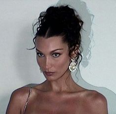 a woman in a wedding dress posing for the camera with her hair pulled back into a bun