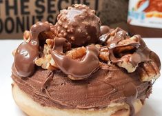 a chocolate covered doughnut with nuts on top