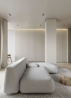 a large white couch sitting on top of a rug in a living room