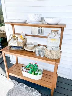 a wooden shelf with drinks and bowls on it