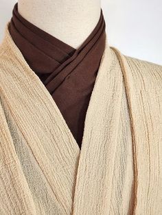 a white mannequin wearing a brown scarf