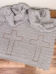 a crocheted blanket laying on top of a wooden floor