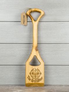 a wooden cutting board with a bottle opener attached to it