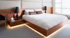 a large bed sitting in a bedroom next to two lamps on either side of it