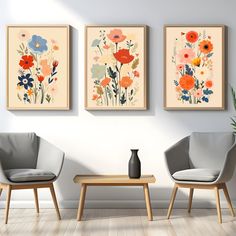 three paintings on the wall above two chairs and a coffee table in front of them