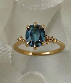 a gold ring with a blue topazte surrounded by diamonds