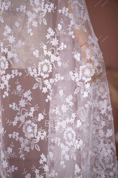 the sheer fabric with white flowers on it