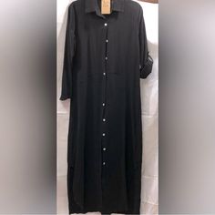 This Black Shirt Dress Features A Long Cuffed Sleeve And A Notched Collar, Perfect For Casual Or Work Occasions. Black Cotton Long Sleeve Maxi Dress, Black Long Sleeve Cotton Maxi Dress, Casual Black Plain Maxi Dress, Elegant Black Button-up Maxi Dress, Casual Black Maxi Dress With Button Closure, Elegant Black Maxi Dress With Button Closure, Casual Button-up Maxi Dress With Button Cuffs, Black Long Sleeve Maxi Dress With Buttons, Black Buttoned Shirt Dress For Daywear