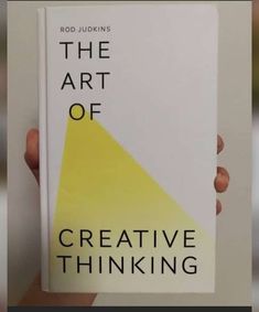 a person holding up a book with the title'the art of creative thinking '