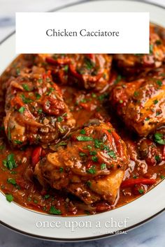 chicken cacciatore in a white bowl with red peppers and parsley on top