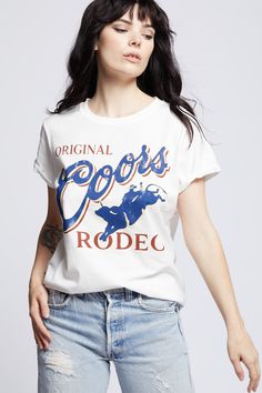 Kick back and take a wild ride with this vintage Original Coors Rodeo tee. In 1987, Coors kicked off the summer with their iconic rodeo events as a tribute to western heritage. This soft cotton fitted tee is perfect for the rodeo, with vintage distressed hems, rolled short sleeves, and a ribbed crewneck. The design of this style is fitted. For a more standard fit choose a size up. Details Style #302145 Color: White Wild Vintage Original Coors Rodeo Fitted T-Shirt 100% Cotton Care/Import Machine Coors Rodeo, Rodeo Events, White Kicks, Fitted Tee, Kick Backs, Cuffed Shorts, Workout Tee, Rodeo, Color White