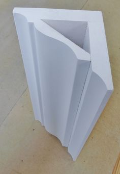 an open white box sitting on top of a wooden table next to a piece of paper