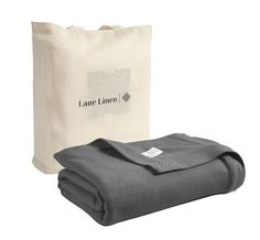 the linen bag is next to two folded blankets and one has a label on it