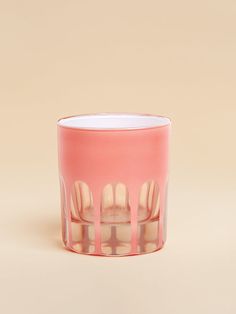 a pink candle holder with tooth prints on the front and sides, sitting on a beige background