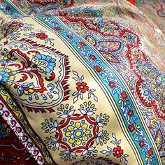 a close up view of a colorfully colored paisley pattern on a bed sheet or comforter