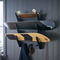 two surfboards are hanging on the wall next to a coat rack and hat rack