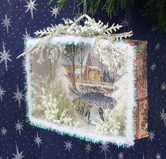 an ornament hanging from a christmas tree with snowflakes and stars on it